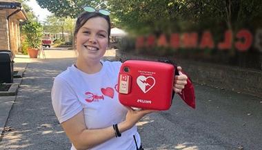 Courtney holds an AED kit