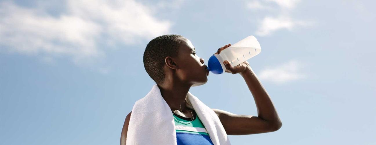 一名妇女在运动后用水瓶喝水.
